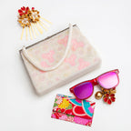 Vintage Japanese beaded clutch bag in pink and white with accessories on white