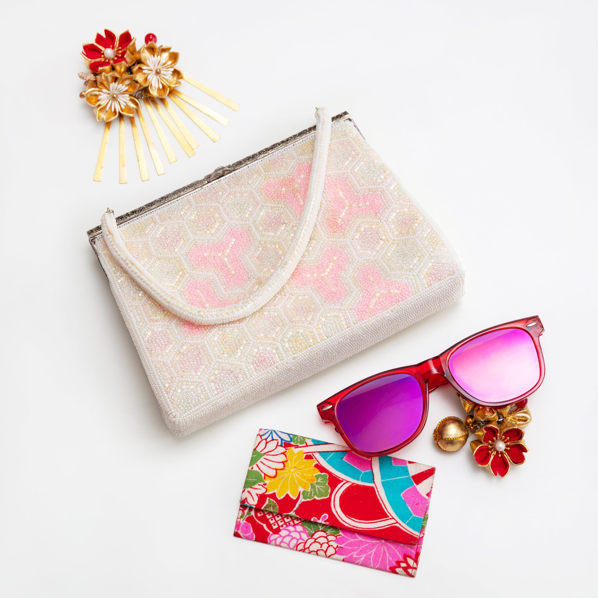 Vintage Japanese beaded clutch bag in pink and white with accessories on white