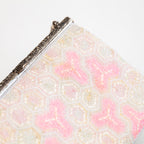 close up of vintage Japanese beaded bag showing beadwork in white and pink and the ornate silver metal frame closure