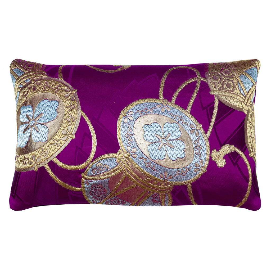 Rectangular purple silk obi cushion with metallic gold drums over purple woven fans.