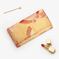 Metallic gold Japanese kimono silk envelope clutch with stylised red butterflies, shown in styled flatlay