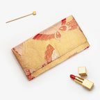 Metallic gold Japanese kimono silk envelope clutch with stylised red butterflies, shown in styled flatlay