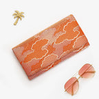 Metallic orange and gold Japanese silk foldover clutch with geometric cloud design, shown in styled flatlay