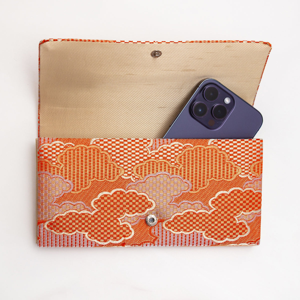 Open orange Japanese silk foldover clutch shown with iPhone 14 Pro Max for scale