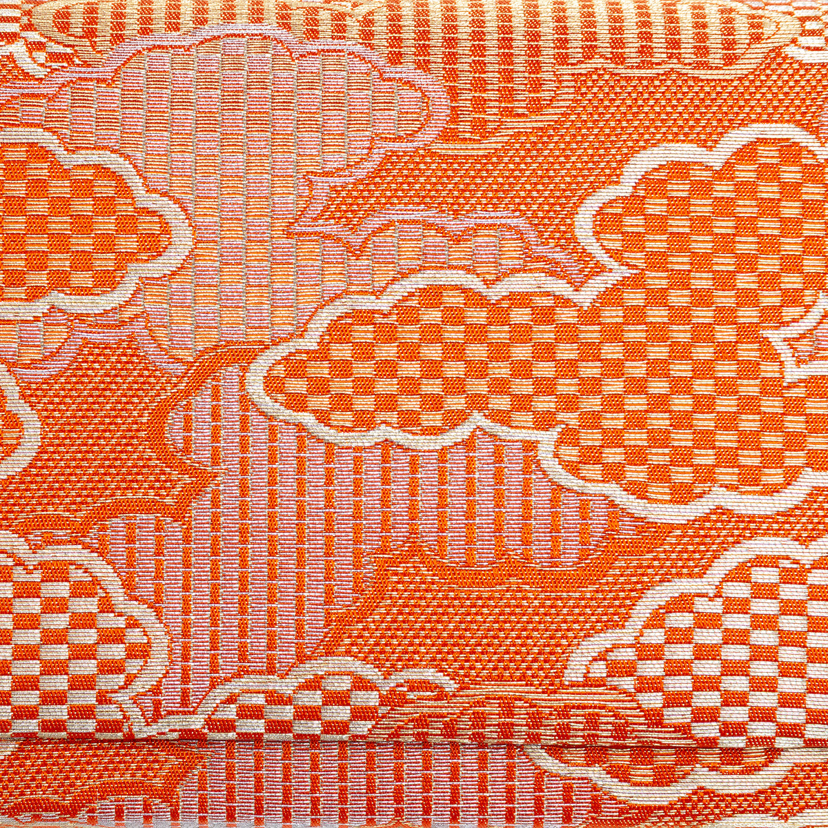 Close-up of geometric gold clouds woven across metallic orange kimono silk