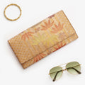 Metallic bronze-gold Japanese kimono silk envelope clutch with bamboo and floral design, shown in styled flatlay