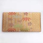 Back of metallic bronze-gold vintage Japanese silk clutch showing small upper-centre mark