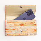 Open pale gold Japanese silk envelope clutch shown with iPhone 14 Pro Max for scale