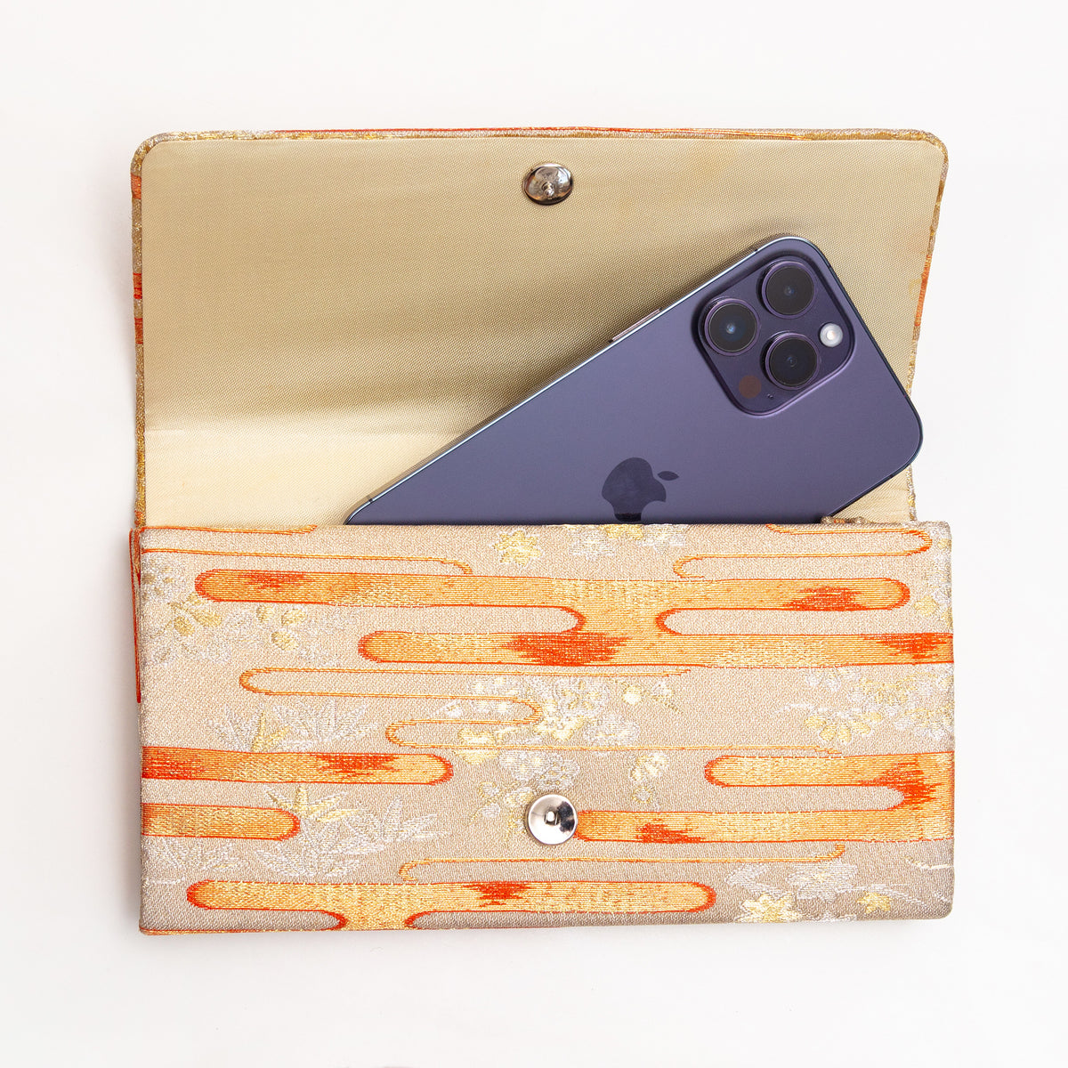 Open pale gold Japanese silk envelope clutch shown with iPhone 14 Pro Max for scale