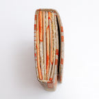 Side view of pale gold Japanese silk envelope clutch showing concertina construction