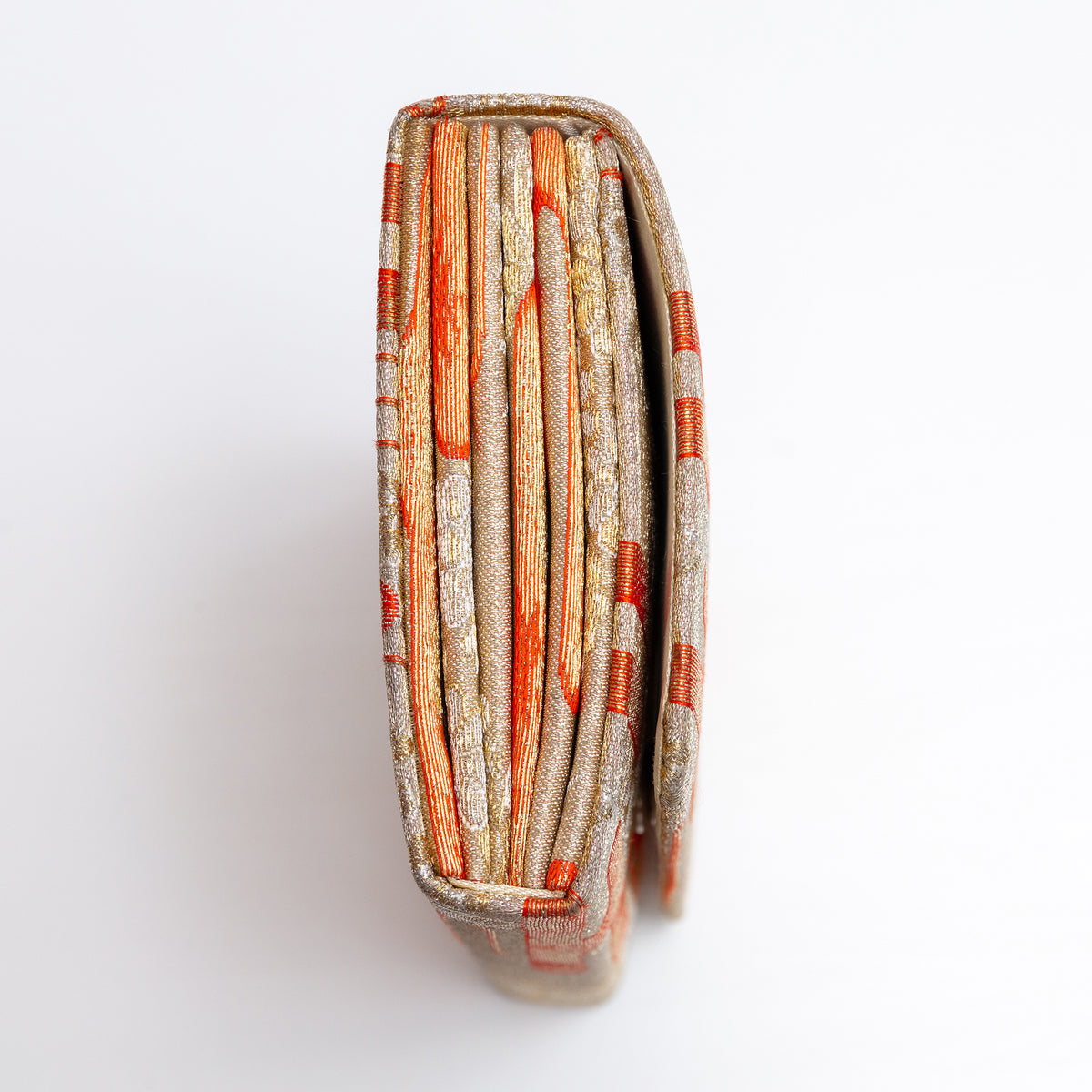 Side view of pale gold Japanese silk envelope clutch showing concertina construction