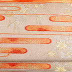 Close-up of orange kasumi mist and delicate gold floral motifs woven into pale gold vintage kimono silk clutch bag