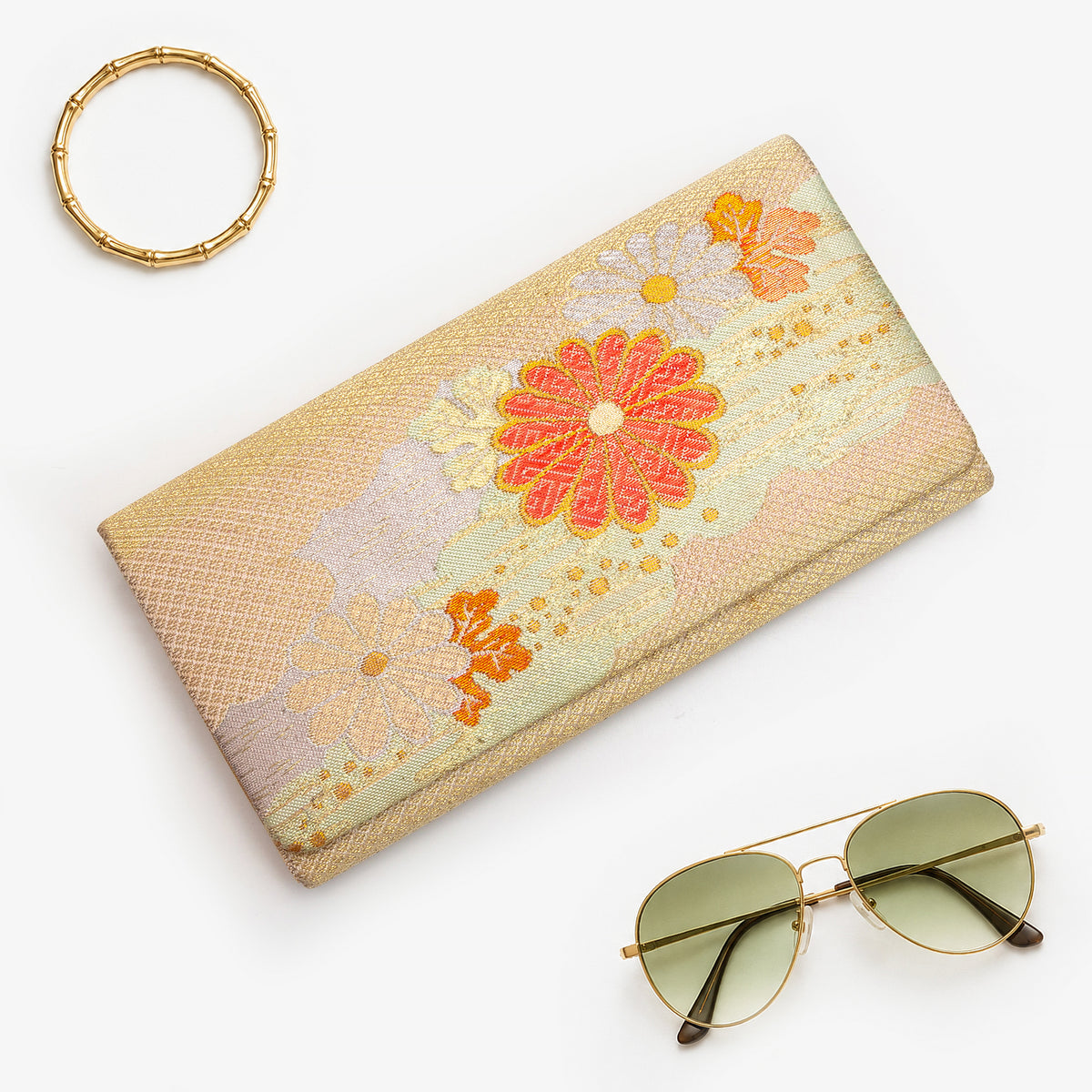 Gold Japanese silk foldover clutch with pale mint green accent and chrysanthemum motif, shown in styled flatlay