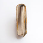 Side view of gold Japanese silk foldover clutch, woven gold and white silk.