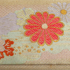 Close-up of chrysanthemum motifs and pale mint green band woven into metallic gold kimono silk
