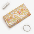 Silver and gold Japanese kimono silk envelope clutch with intricate floral design, shown in styled flatlay