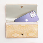 Open pale gold Japanese silk foldover clutch shown with iPhone 14 Pro Max for scale