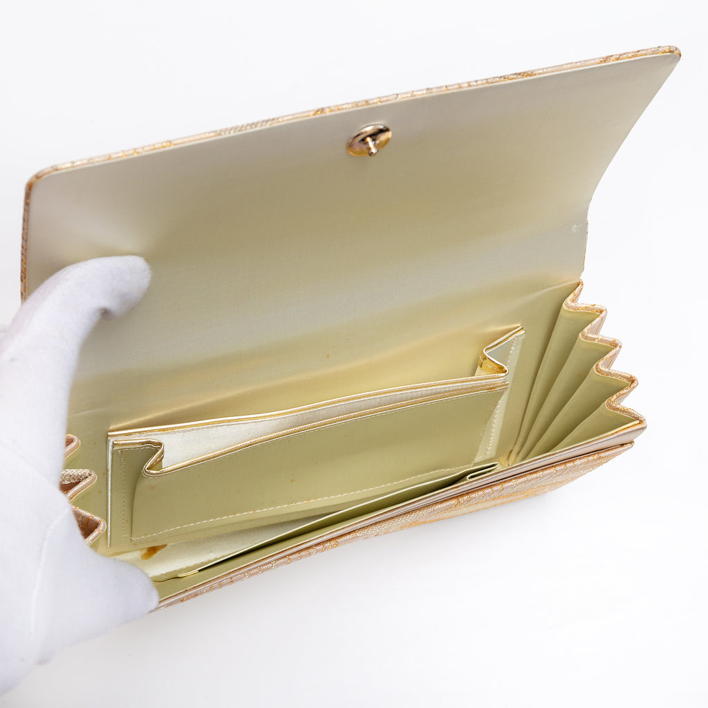 Cream silk interior with three pockets inside vintage Japanese foldover clutch, mark in base interior.
