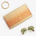 Gold and orange Japanese silk foldover clutch with chrysanthemum ombré design, shown in styled flatlay