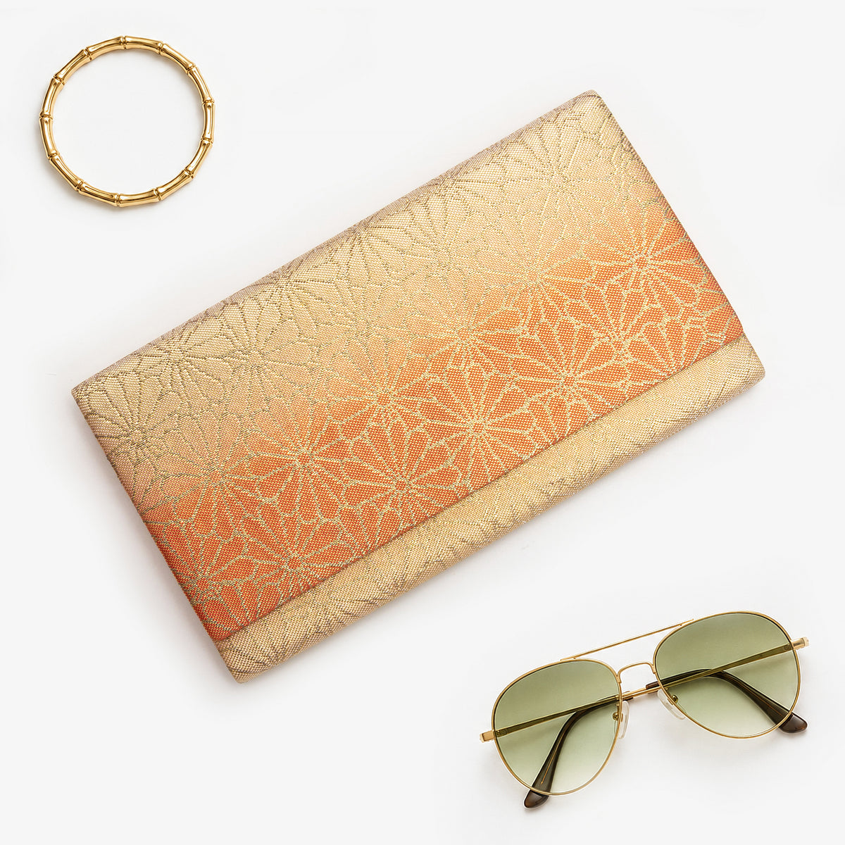 Gold and orange Japanese silk foldover clutch with chrysanthemum ombré design, shown in styled flatlay