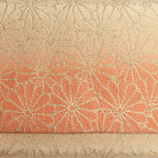 Close-up of orange-to-gold ombré kimono silk woven with Kiku chrysanthemum motifs