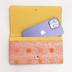 Open peach and silver Japanese silk envelope clutch shown with iPhone 14 Pro Max for scale