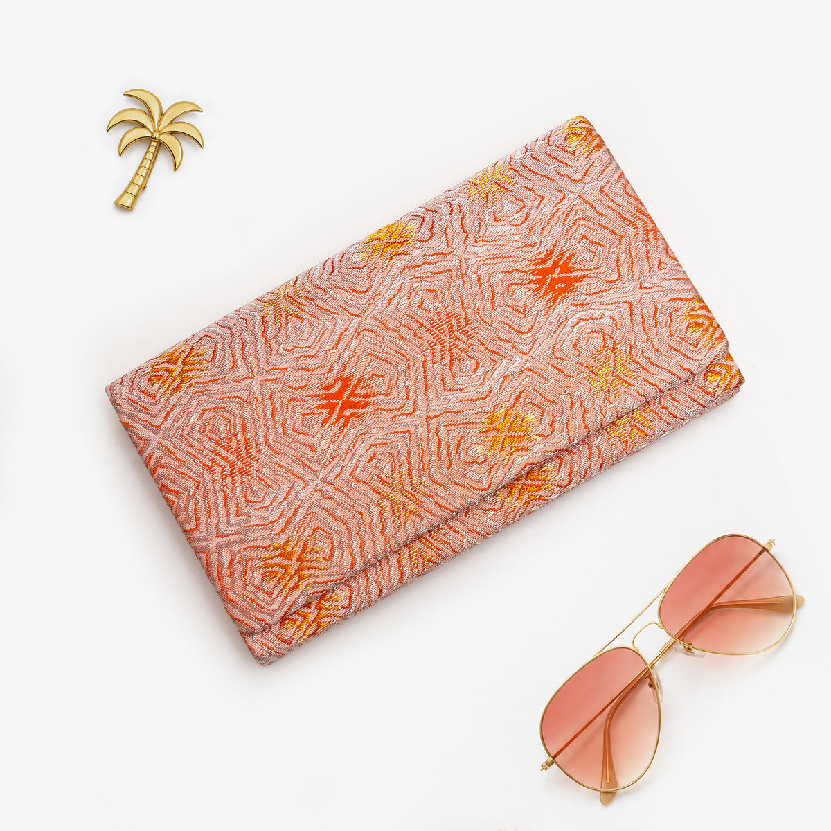 Peach and silver Japanese kimono silk envelope clutch with hypnotic abstract geometric design, shown in styled flatlay