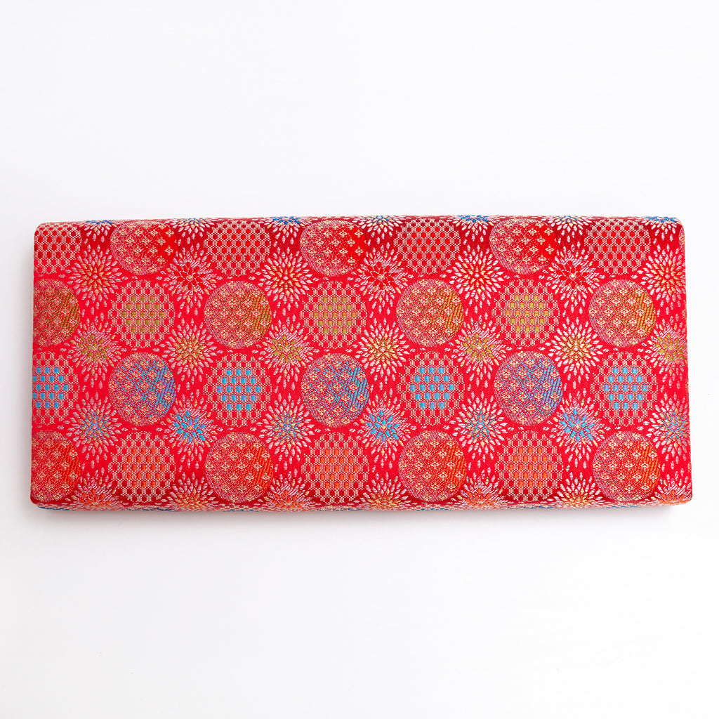 Back of vermilion red Japanese silk envelope clutch with repeating woven starburst pattern
