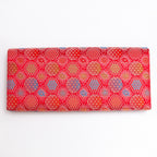 Back of vermilion red Japanese silk envelope clutch with repeating woven starburst pattern