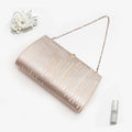 Pale gold and silver Japanese kimono silk clutch bag  with trees pattern in a styled flatlay on white.