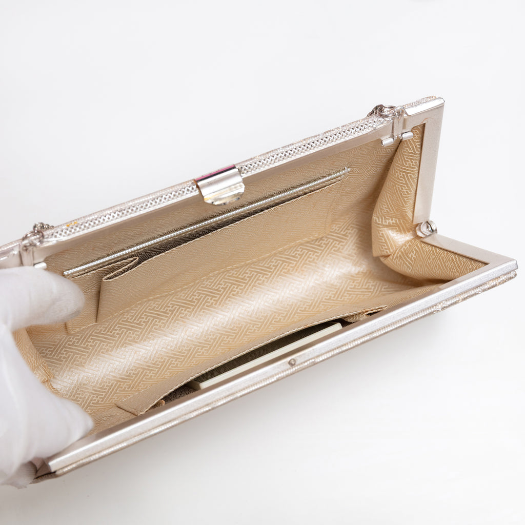 Pale gold silk clutch bag with silver-tone chain extended outwards, original mirror