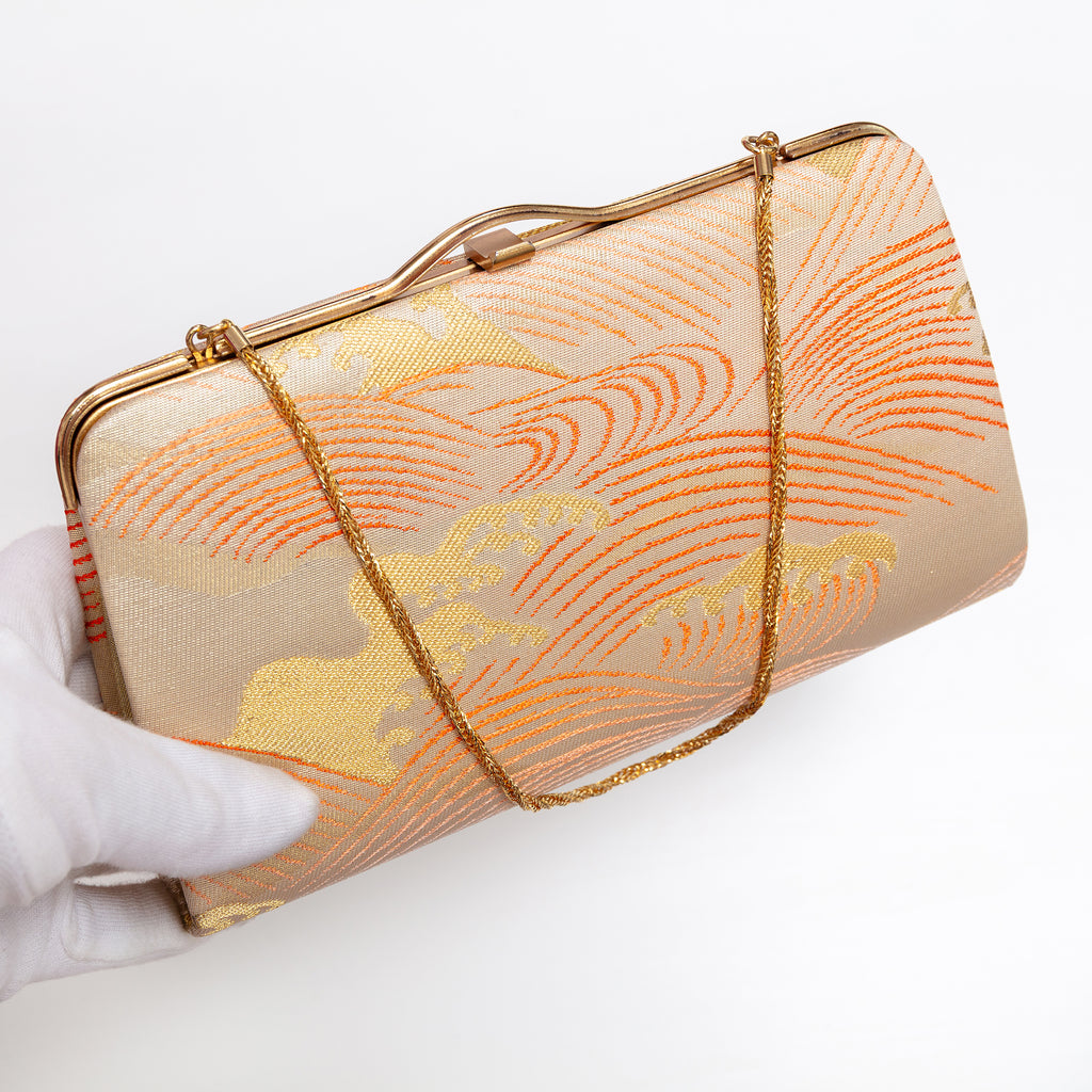 Japanese kimono silk clutch bag with gold-tone frame shown at an angle with gold chain strap