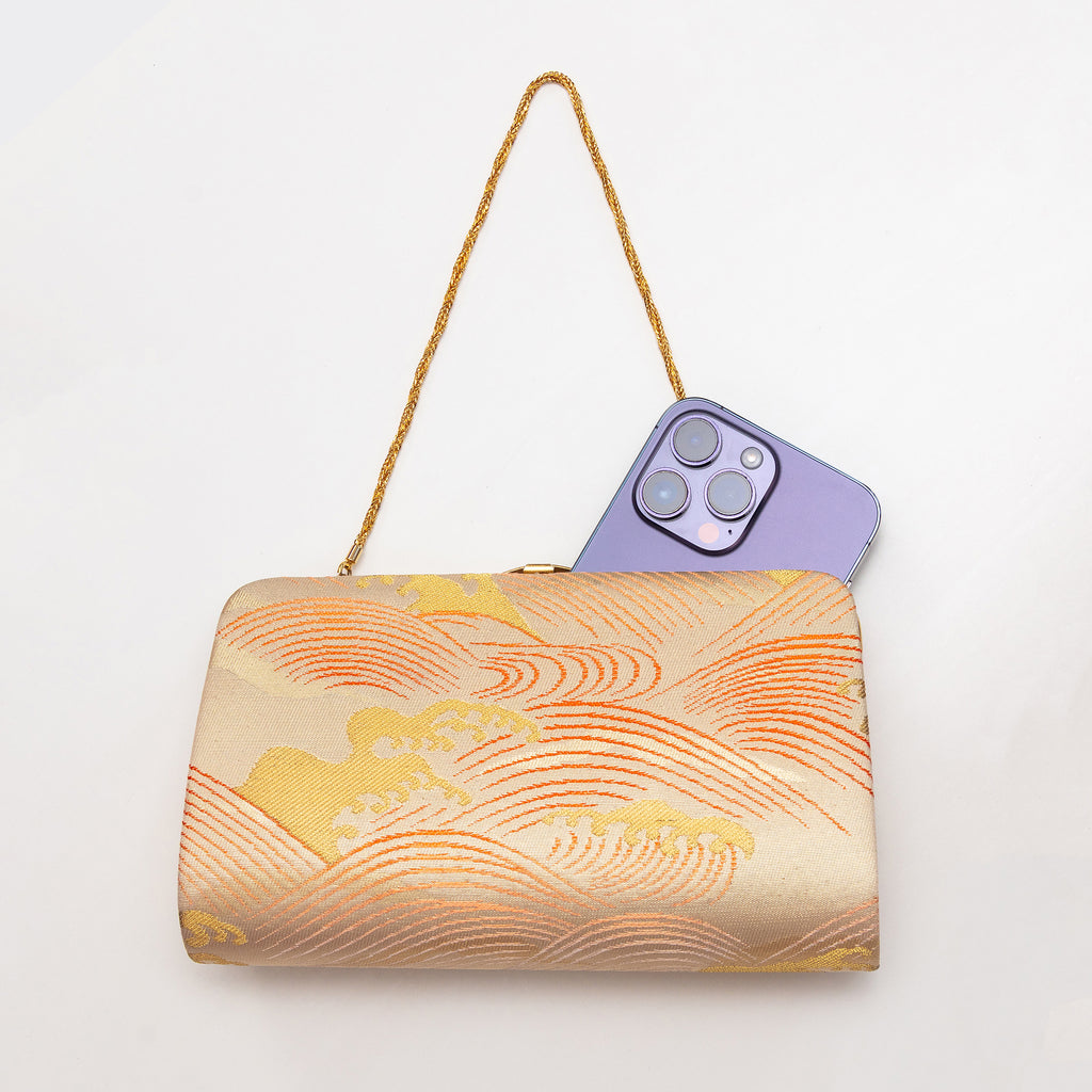 Vintage Japanese wild wave clutch shown with iPhone 14 Pro Max for scale