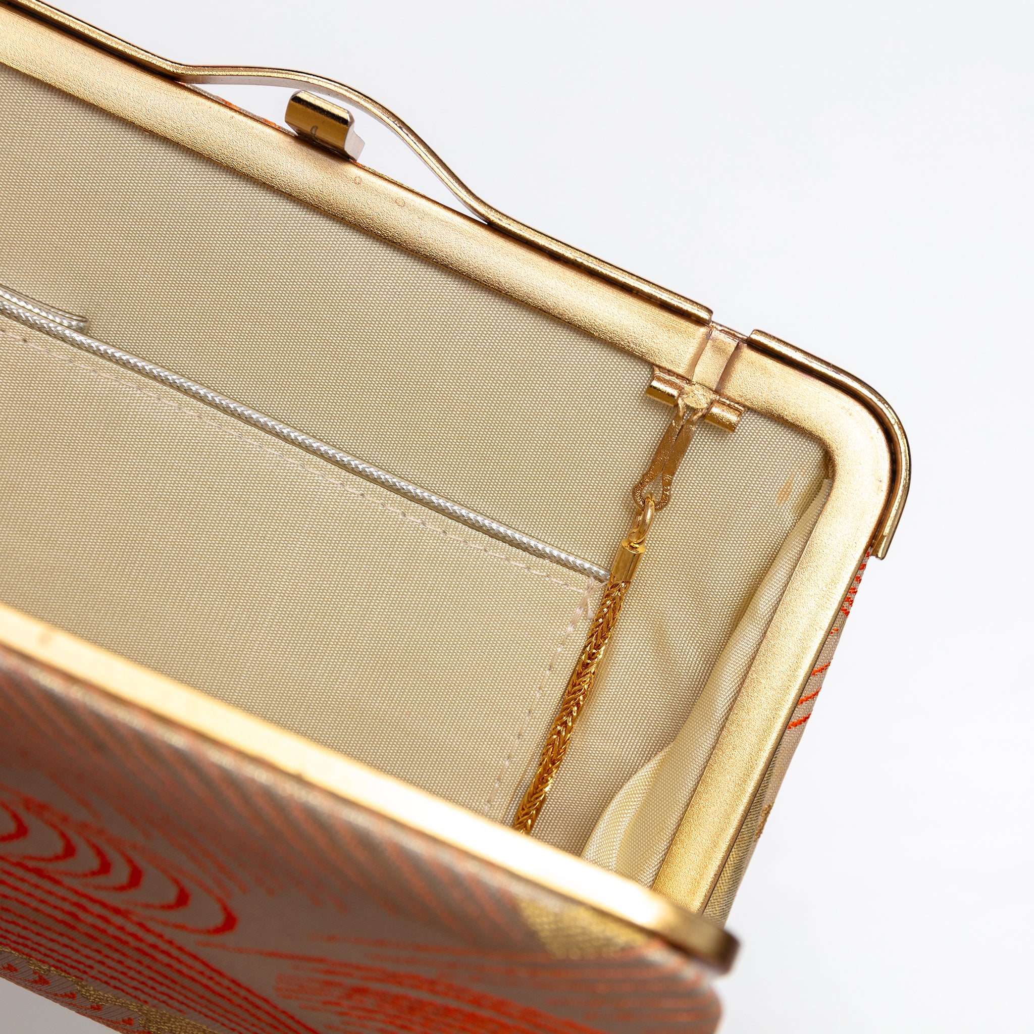 Open vintage Japanese silk clutch bag with cream silk interior and tuck away strap hinges.