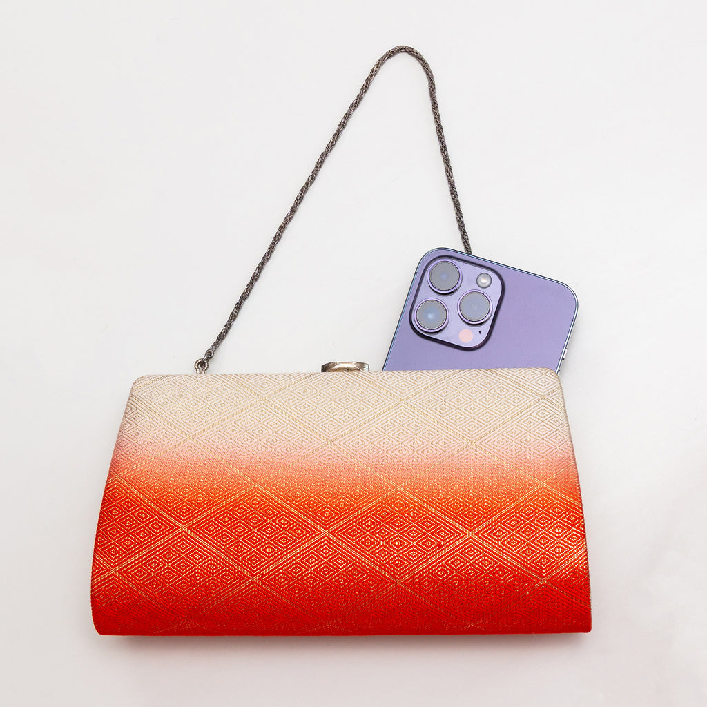 Orange and cream Japanese kimono silk clutch bag shown with iPhone 14 Pro Max for scale