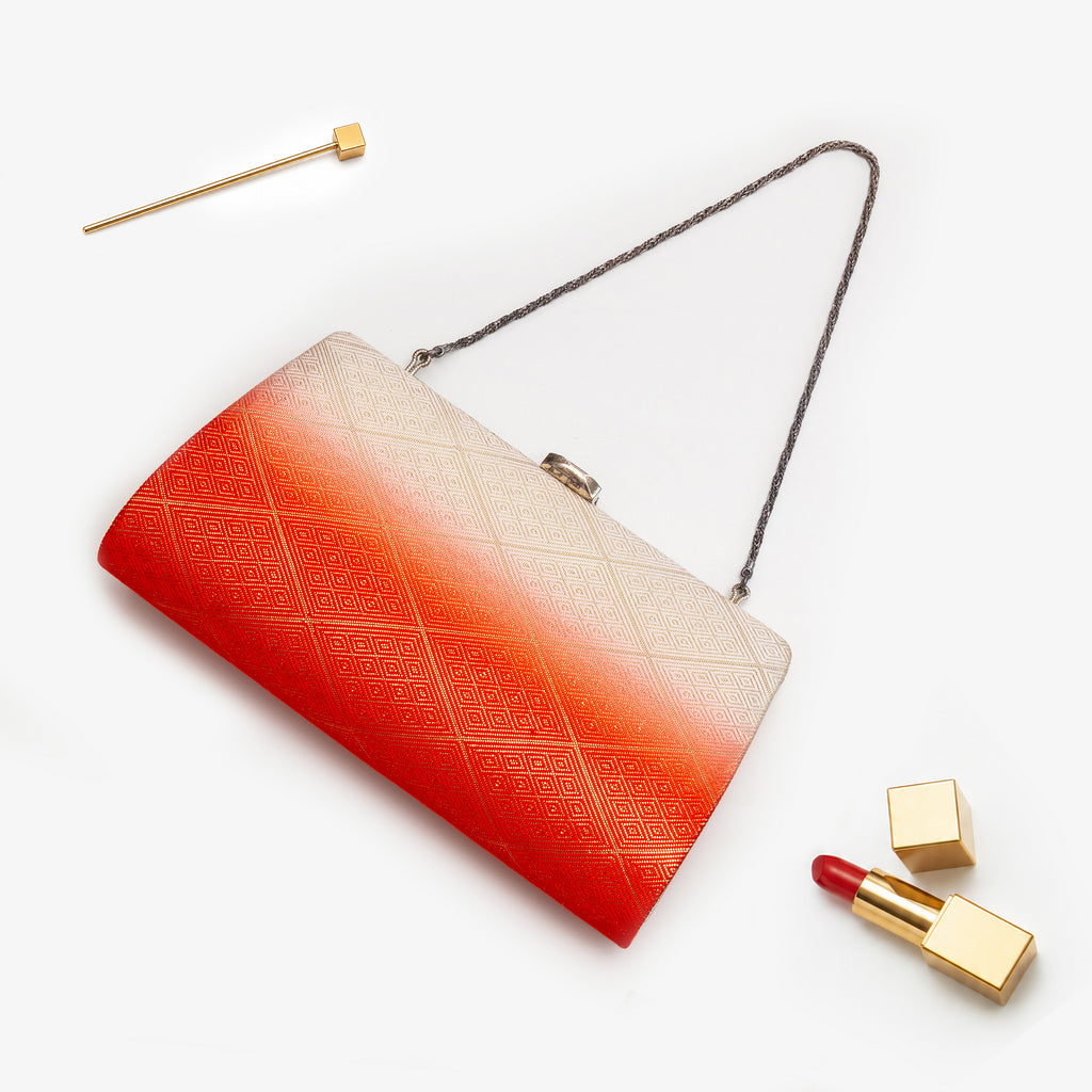 Orange and cream Japanese kimono silk clutch bag with gold diamond pattern, shown in styled flatlay