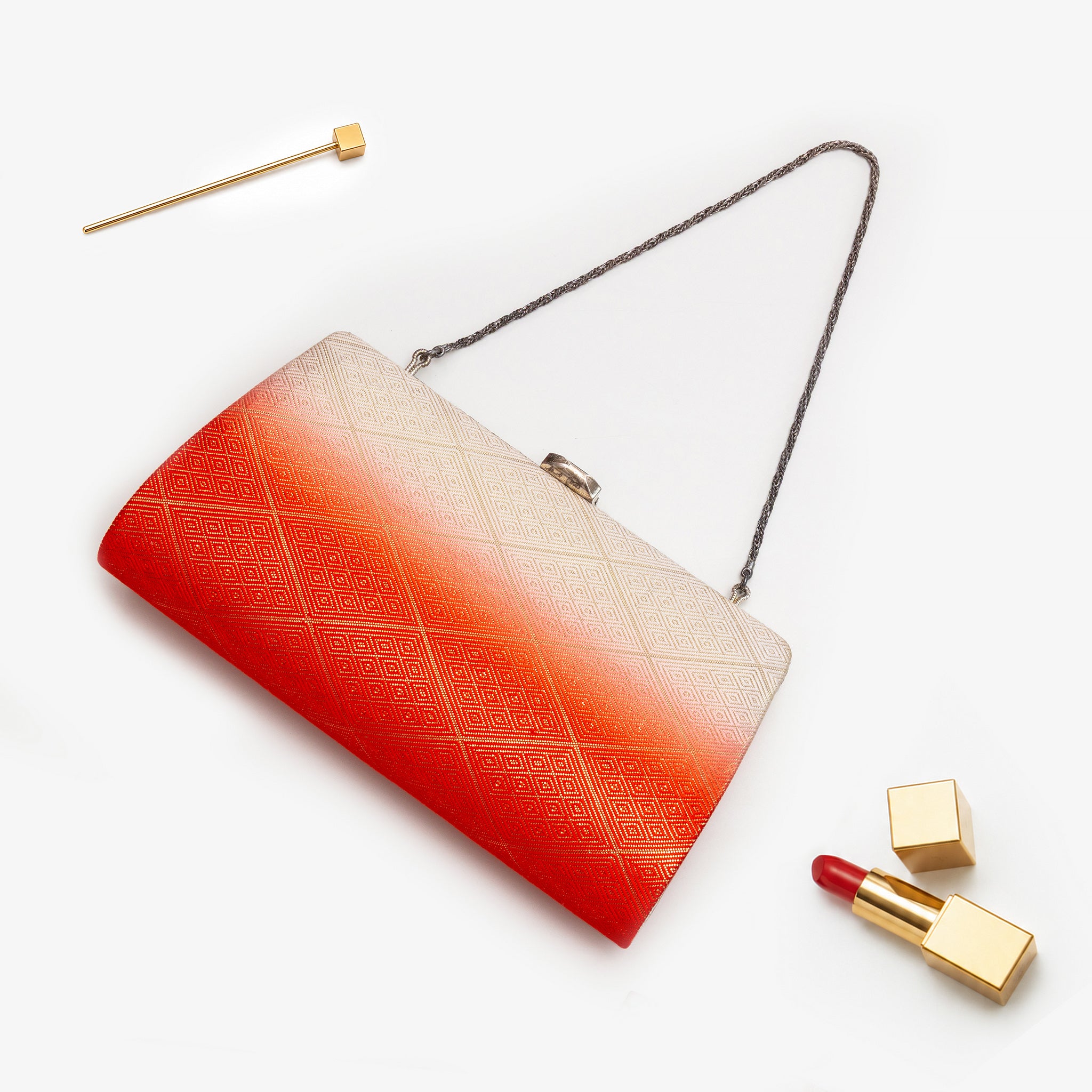 Orange and cream Japanese kimono silk clutch bag with gold diamond pattern, shown in styled flatlay