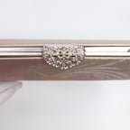 Close-up of statement marcasite silver-tone clasp with heart-shaped details on a vintage 1970s Japanese silk clutch bag in pink and silver