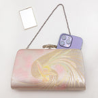 Iridescent Japanese phoenix clutch bag shown with iPhone 14 Pro Max for scale. Mirror included with bag.