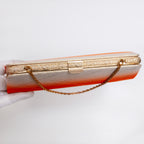 Top view of gold-tone clasp and textured gold-tone frame on vintage Japanese clutch bag. Gold chain strap.