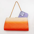 Orange and cream Japanese kimono silk clutch bag shown with iPhone 14 Pro Max for scale. Orange to cream ombre with gold geometric diamond pattern design.