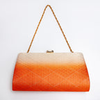 A rectangular vintage Japanese 1970s clutch bag with a gold chain strap and a gold clasp, featuring a textured diamond pattern that fades from cream at the top to bright orange at the bottom, set against a plain white background.