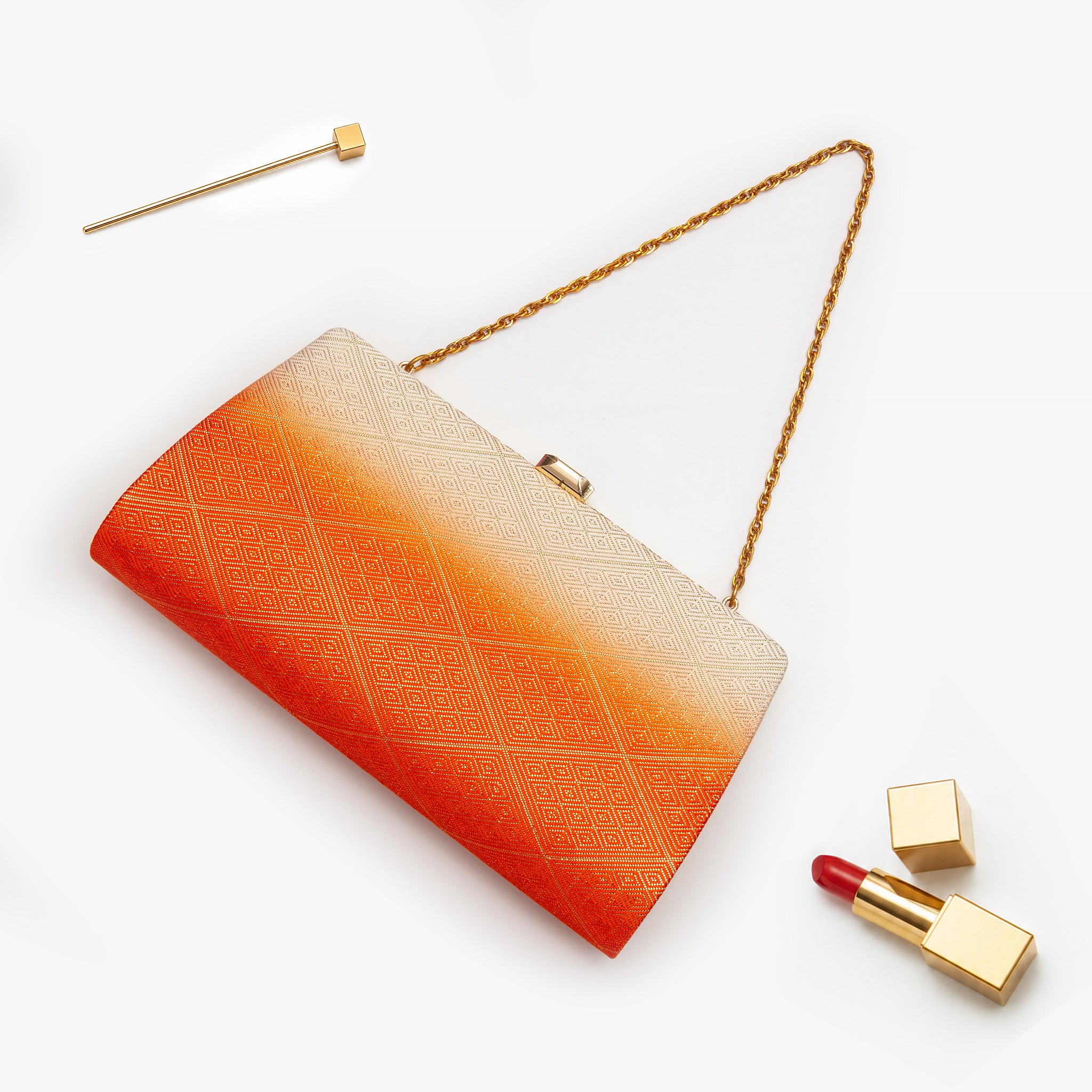 Spiced orange and cream metallic Japanese kimono silk clutch bag with gold geometric diamond pattern, shown in styled flatlay