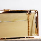 Close-up of fold-away chain hinge inside gold-tone metal frame. Some marks inside.