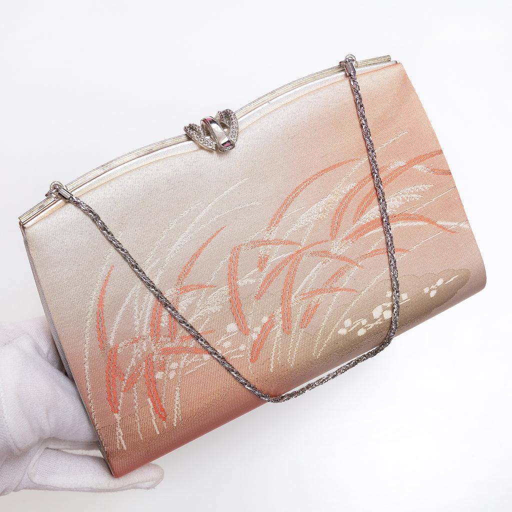 Windswept grass vintage kimono silk clutch bag held at three-quarter view with silver-tone chain extended and fancy silver clasp.