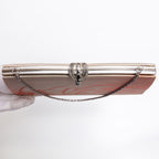 A vintage Japanese kimono silk evening clutch bag with a silver-tone metal frame, a decorative clasp, and a chain strap, held by a gloved hand against a white background.