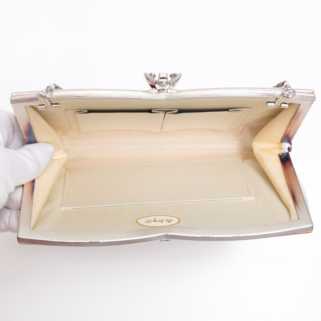 Open vintage Japanese silk clutch bag with silver-tone chain extended, cream silk lining and original paper sticker inside bag.