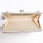 Open vintage Japanese silk clutch bag with silver-tone chain extended, cream silk lining and original paper sticker inside bag.