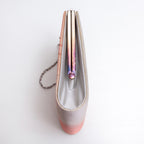 Side view of metallic peach and silver Japanese kimono silk clutch bag showing rainbow-toned tarnish to the frame and silver silk side panel, silver chain strap.