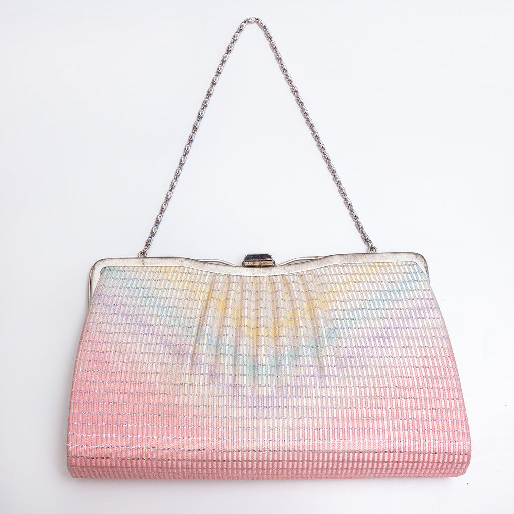A vintage Japanese 1970s silk evening clutch bag with a pleated, textured surface featuring a pastel rainbow gradient fading from pink at the bottom to light blue and yellow at the top. It has a silver-tone metal frame and a silver chain shoulder strap, photographed against a plain white background.
